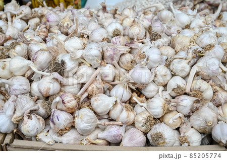 Fresh garlic for sale at vegetable market, close up. Boxes full of raw garlic in shop. Organic garlic at the greengrocer's stall. Vegetable. Fresh garlic for sale at vegetable market, close up. Boxes full of raw garlic in shop. Organic garlic at the greengrocer's stall. Vegetable. 85205774