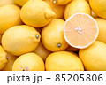 Fresh and delicious lemons for sale at vegetable market, close up. Boxes full of lemons in shop. Lemon at the greengrocer's stall. Fruit market. 85205806