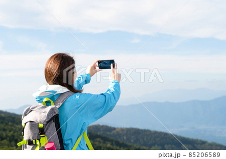 登山後頂上でスマホの撮影をする日本人女性 コピースペースあり 85206589