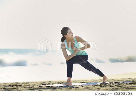 砂浜でヨガをする若い女性 85208558