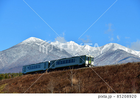 北杜市小淵沢町、雪の八ヶ岳を背景に小海線小淵沢築堤を行く列車 北杜市小淵沢町、雪の八ヶ岳を背景に小海線小淵沢築堤を行く列車 85208920