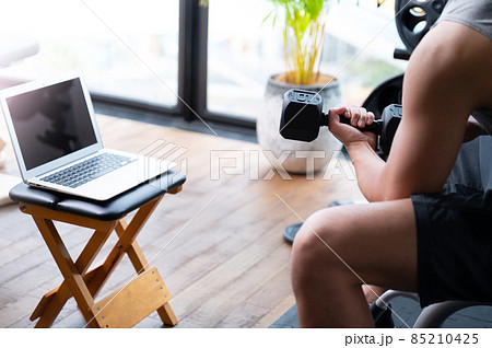 オンライントレーニングをしながら教える筋肉が美しいトレーナーとパソコン　 85210425