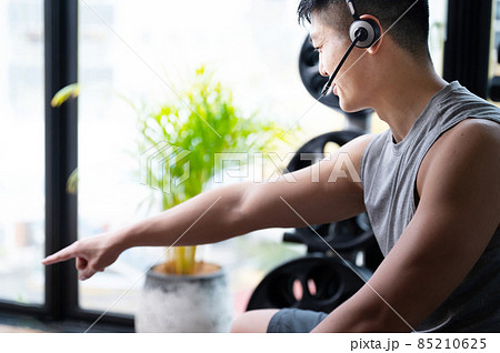 オンライントレーニングをしながら指示する筋肉が美しいトレーナー 85210625