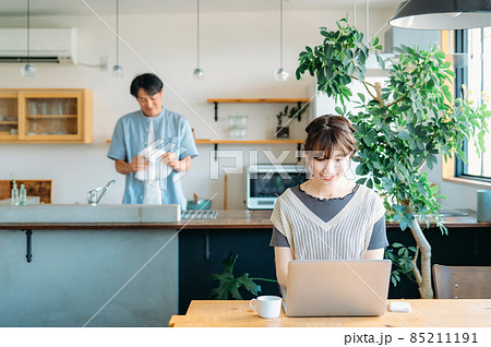 仕事する女性と家事をする男性（笑顔） 85211191