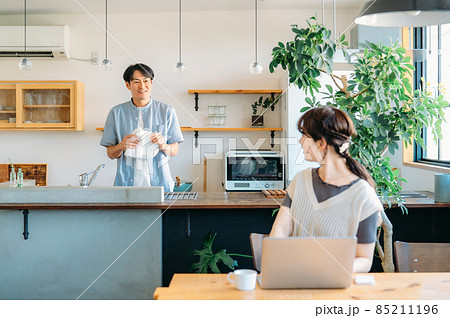 仕事する女性と家事をする男性（笑顔） 85211196