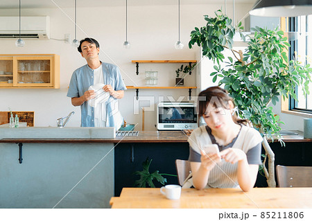スマホを見る女性と疑う男性(退屈) スマホを見る女性と疑う男性(退屈) 85211806