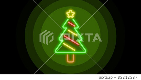 Digital composite of illuminated christmas tree on green circular pattern over black background 85212537