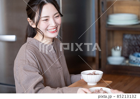 旦那さんにおかわりの配膳するかわいい日本人の新婚の奥さん 85213132