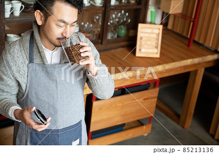 豆をかぐ違いのわかるカフェのマスター風の日本人男性 やや俯瞰 コピースペースあり 豆をかぐ違いのわかるカフェのマスター風の日本人男性 やや俯瞰 コピースペースあり 85213136
