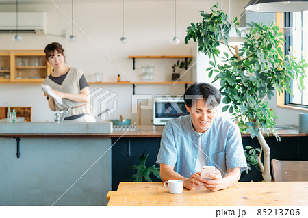 家でくつろぐ仲の良い夫婦（スマホ） 85213706