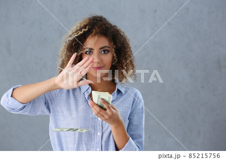 Latino american young woman throwing money away from hand, bunch of cash 85215756