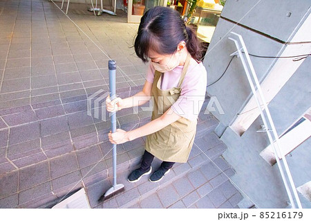 マンションの共用部を箒で掃くエプロン姿の女性 マンションの共用部を箒で掃くエプロン姿の女性 85216179