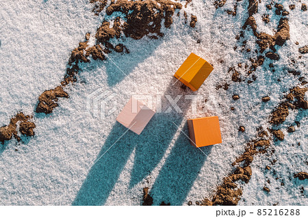 Winter landscape with miniature model of wooden houses with sunlighton winter snow background. Home, loan, money investment concept. Flat lay 85216288