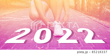 Cropped image of sports women hands tying laces off white sneakers outdoor for the run training, healthy exercise workout concept 85216337