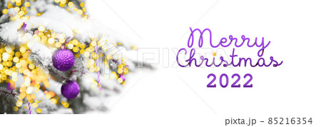 2022 Merry Christmas and New years Holiday web banner background. Template with Christmas lilac balls, snow on fir tree and lights. 2022 Merry Christmas and New years Holiday web banner background. Template with Christmas lilac balls, snow on fir tree and lights. 85216354