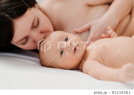 breastfeeding. the baby lies next to the mother after feeding breastfeeding. the baby lies next to the mother after feeding 85216561