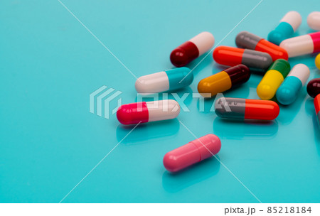 Antibiotic capsule pills on blue background. Prescription drugs. Colorful capsule pills. Antibiotic drug resistance concept. Pharmaceutical industry. Superbug problems. Medicament and pharmacology. 85218184