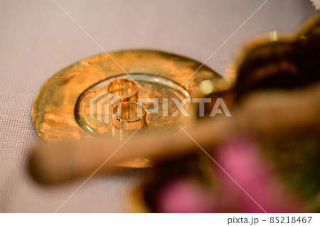 Gold rings lie on a gold plate in the church, the wedding process. Gold rings lie on a gold plate in the church, the wedding process. 85218467