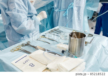 scrub nurse preparing medical instruments for operation 85218522