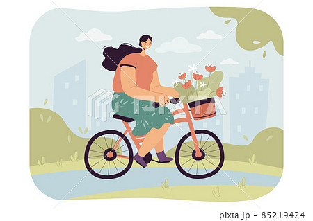 Happy young woman riding bike with bouquet of flowers in basket 85219424