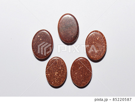 Natural oval cabochon brown aventurine gold on the white background 85220587