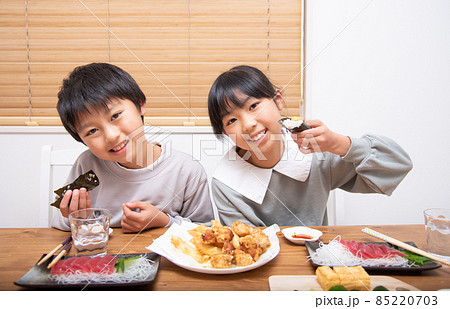 家で晩御飯を食べる小学生の男の子と女の子 85220703