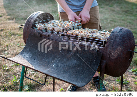 cooking raw meat in a grid on the barbeque grill 85220990