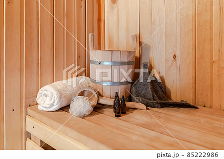 Traditional old Russian bathhouse SPA Concept. Interior details Finnish sauna steam room with traditional sauna accessories set basin towel aroma oil scoop felt. Relax country village bath concept Traditional old Russian bathhouse SPA Concept. Interior details Finnish sauna steam room with traditional sauna accessories set basin towel aroma oil scoop felt. Relax country village bath concept 85222986