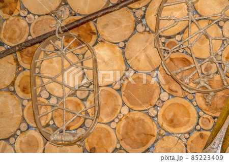 Vintage old snow shoes on wood log wall 85223409