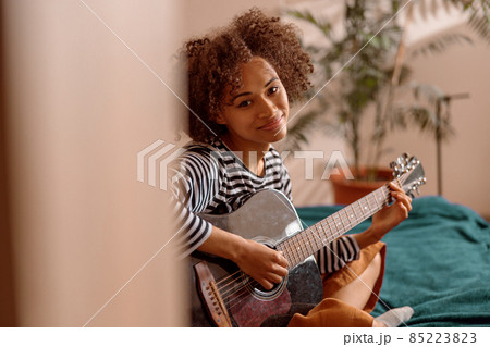 Female musician guitarist playing guitar at home Female musician guitarist playing guitar at home 85223823