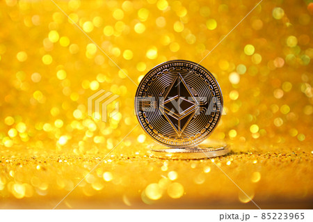 The reverse side is ether. Cryptocurrency ether is the coin of the future. Golden ether. Golden shiny background. High quality photo The reverse side is ether. Cryptocurrency ether is the coin of the future. Golden ether. Golden shiny background. High quality photo 85223965