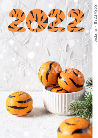 Tangerines with painted stripes. The concept for the tiger new year with a Christmas tree. Tiger mandarines Tangerines with painted stripes. The concept for the tiger new year with a Christmas tree. Tiger mandarines 85224565