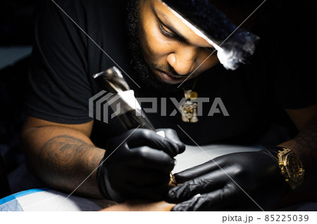 Portrait of tattoo artist concentrated on his work. Closeup Portrait of tattoo artist concentrated on his work. Closeup 85225039
