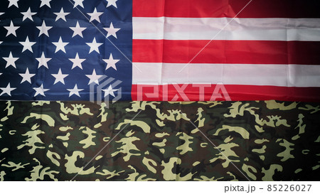 American flag and Military camouflage pattern. Top view angle. Soldier flag with national American flag on white background. Represent military concept by camouflage fabric and USA national flag. 85226027