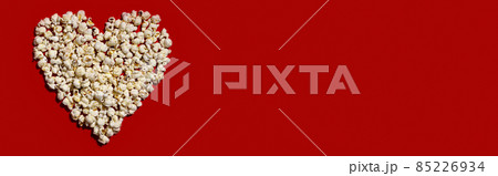 Heart made of popcorn on red background Heart made of popcorn on red background 85226934