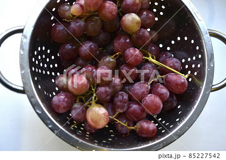 Freshly washed red grapes in a colander 85227542
