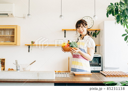 キッチンで野菜を持つ女性 85231138