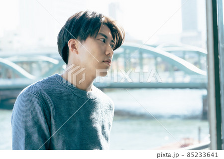 窓辺でリラックスする若い男性 85233641