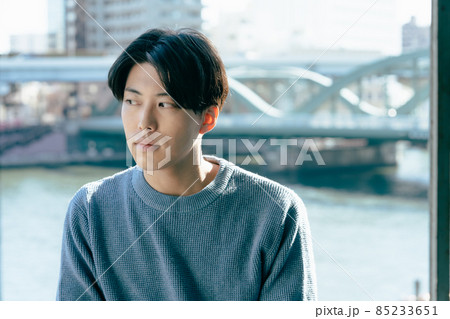 窓辺でリラックスする若い男性 窓辺でリラックスする若い男性 85233651