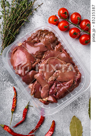 Poultry offal Chicken liver in a plastic container, on gray stone table background, top view flat lay 85235387