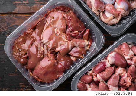 Fresh turkey industrial production, farm turkey liver in a vacuum, on old dark wooden table background, top view flat lay 85235392