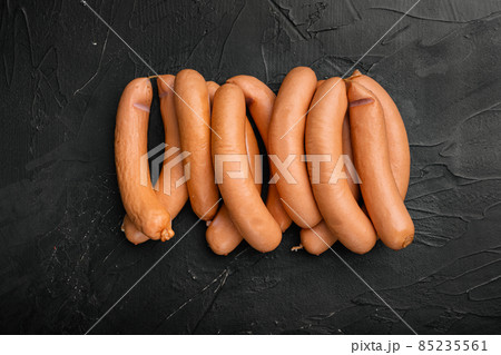 Raw sausage, on black dark stone table background, top view flat lay, with copy space for text Raw sausage, on black dark stone table background, top view flat lay, with copy space for text 85235561