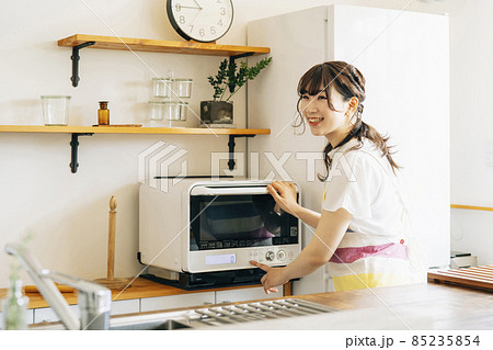 電子レンジを使う女性（笑顔） 85235854