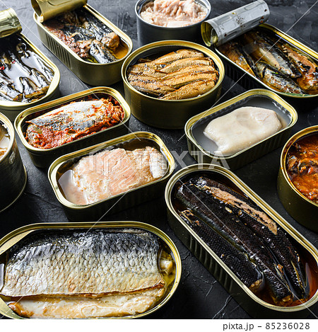 Tin can of Saury, mackerel, sprats, sardines, pilchard, squid, tuna Open and closed over black slate background side view square Tin can of Saury, mackerel, sprats, sardines, pilchard, squid, tuna Open and closed over black slate background side view square 85236028