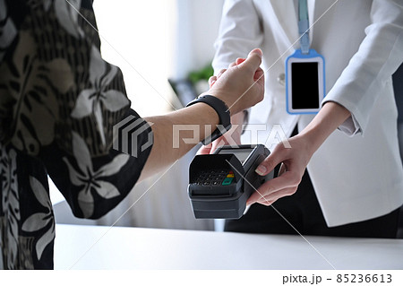 Customer using smart watch for payment at restaurant. Concept of cashless technology and credit card payment. Customer using smart watch for payment at restaurant. Concept of cashless technology and credit card payment. 85236613