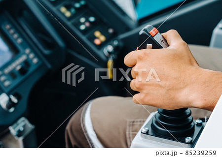 Close-up of a hand holding a joystick to control a crane.Construction concept 85239259