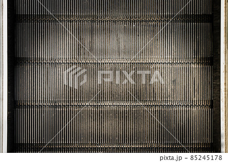 Detail shot of moving steps at the bottom of a conventional escalator with sensor. 85245178