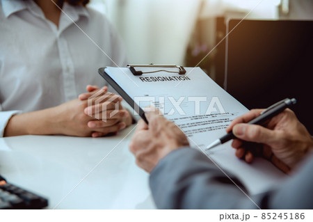 The boss signs the resignation letter to the female employee. The boss signs the resignation letter to the female employee. 85245186