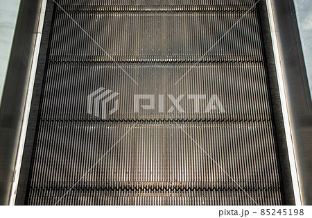 Detail shot of moving steps at the bottom of a conventional escalator with sensor. Detail shot of moving steps at the bottom of a conventional escalator with sensor. 85245198