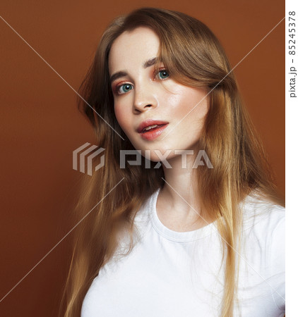 young pretty girl with blond hair posing cheerful on brown background, lifestyle people concept young pretty girl with blond hair posing cheerful on brown background, lifestyle people concept 85245378